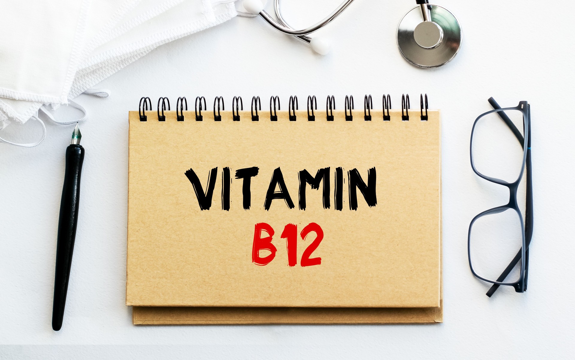 Inscription - VITAMIN B12. Written in a notepad to remind you of what's important. Top view of the table along with a stethoscope and a mask. Health care concept.